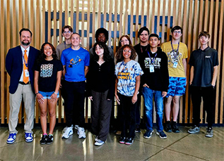 Group of happy students with a staff member posing for a picture