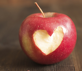 red apple with a heart-shape bite