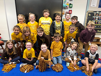 K-5 Roller Skating Field Trip Group Photo Group of happy early learning childhood center students posing for a group photo with cheerleading pom poms