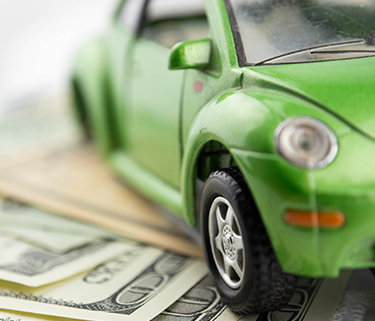 Green car next to cash representing donation concept
